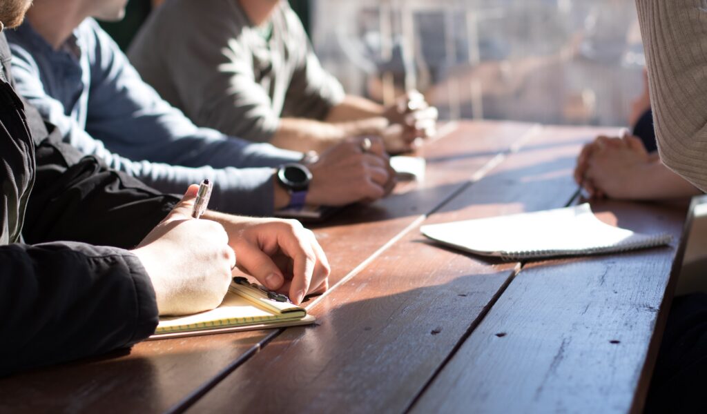 People taking notes in a meeting