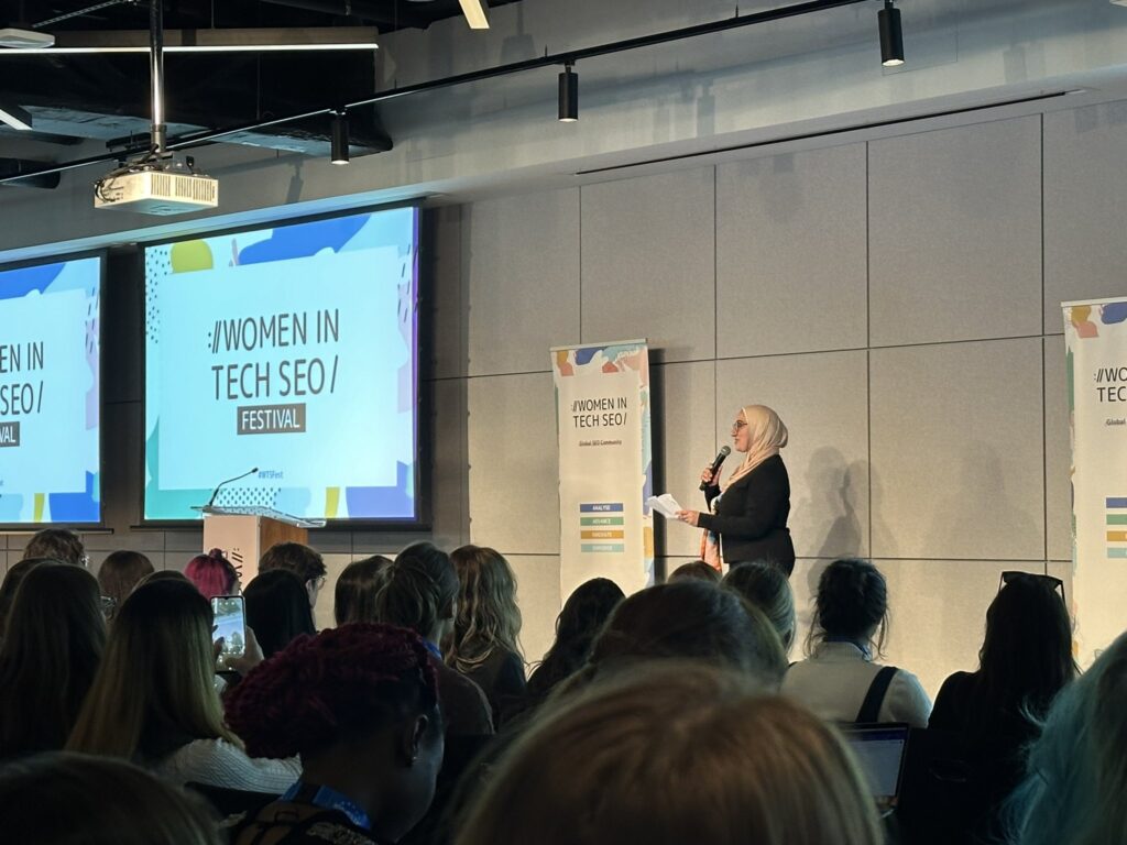 Photo of the opening remarks at the Women in Tech SEO (WTS) event in London 2024 – Founder Areej AbuAli speaking on stage.